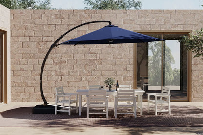 Outdoor patio set with a large blue cantilever umbrella in front of a stone wall.