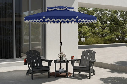 Blue and white striped patio umbrella over two Adirondack chairs on a patio.