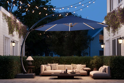 Outdoor patio setup with a large umbrella, couch, and coffee table under string lights.
