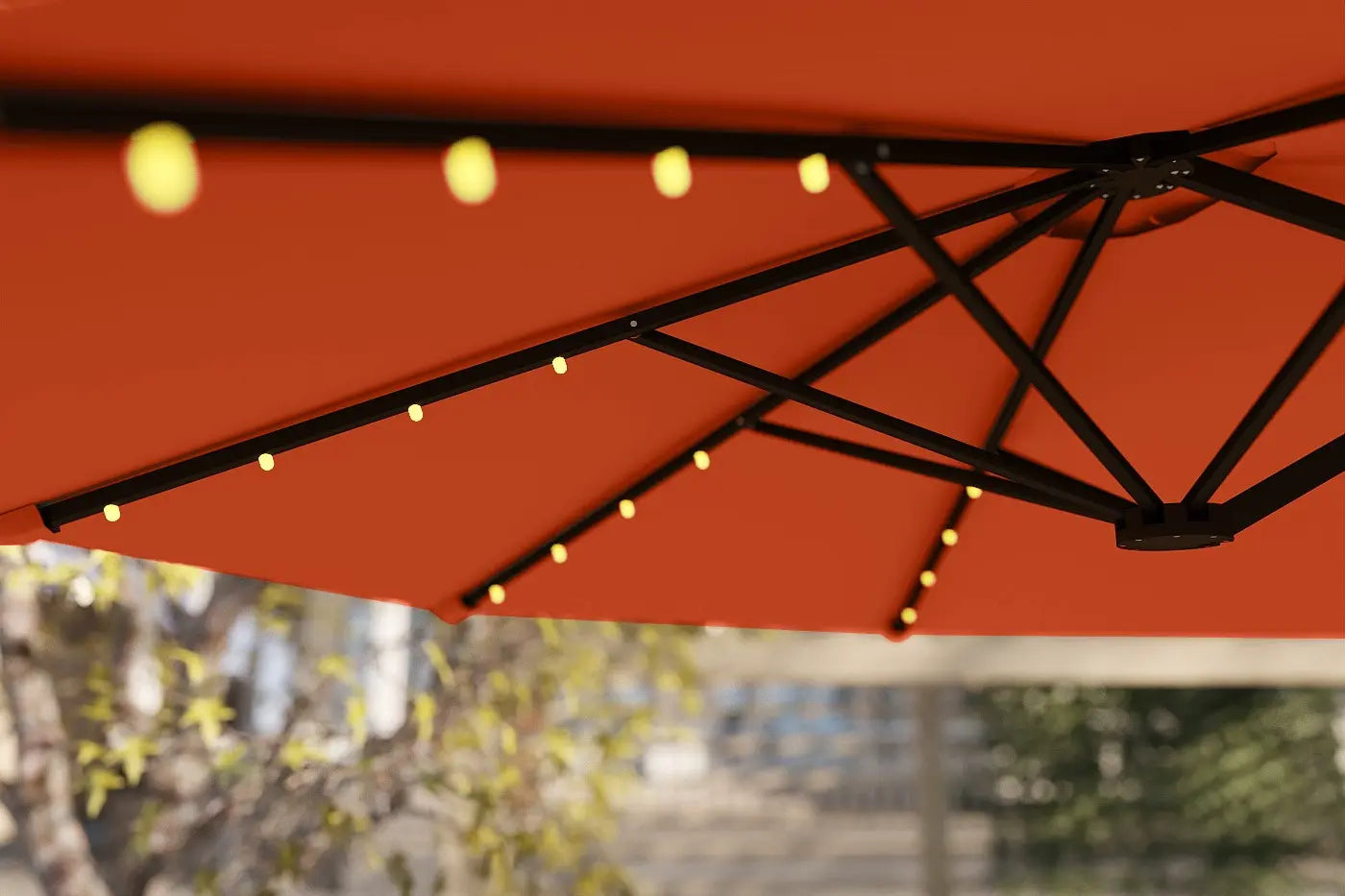 Red patio umbrella with string lights against a blurred outdoor background