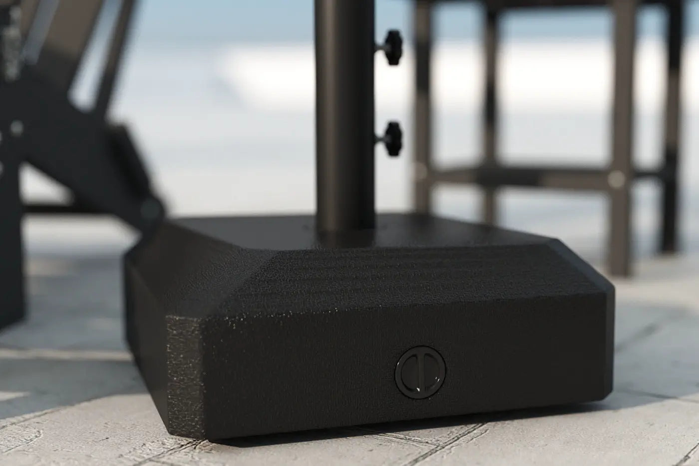 Black outdoor umbrella base on a patio with blurred background