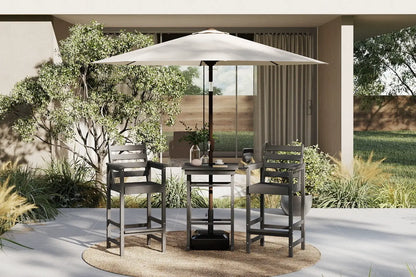 Outdoor patio set with table and chairs under a large umbrella on a patio.