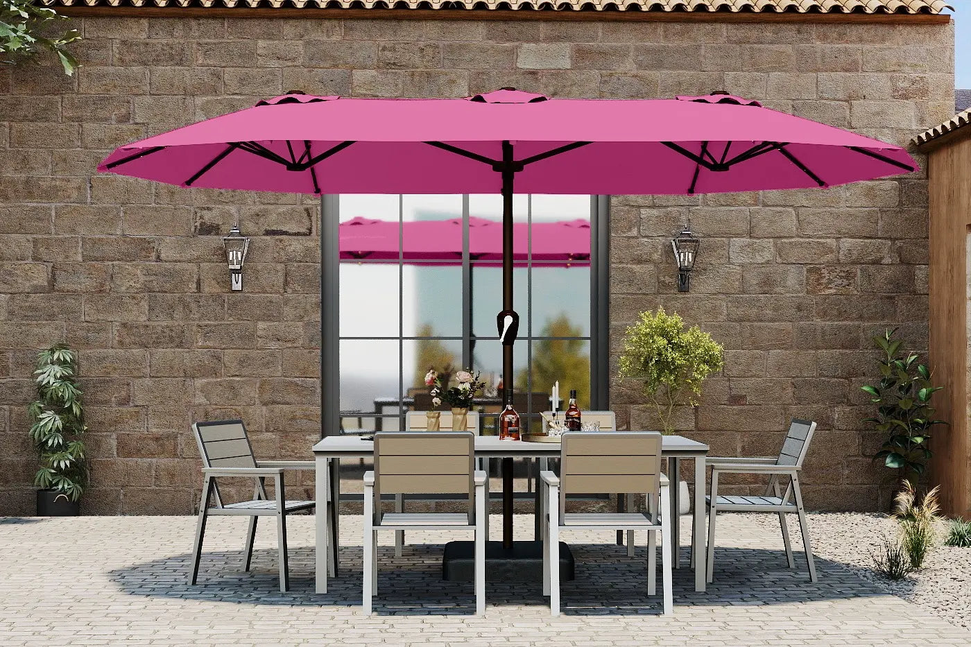 Outdoor patio set with a pink umbrella in front of a stone building.