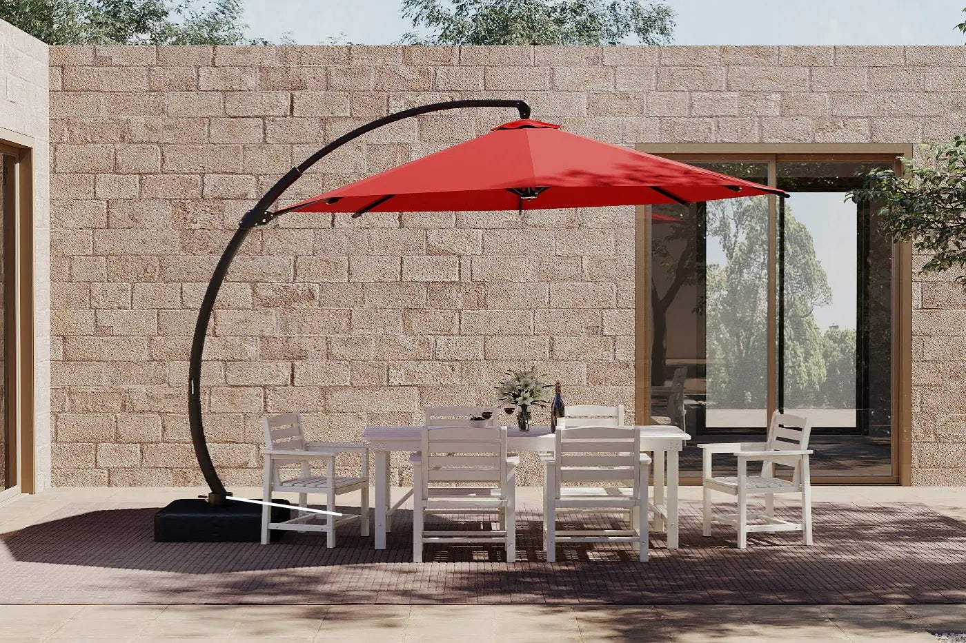 Outdoor patio set with a red cantilever umbrella against a stone wall.