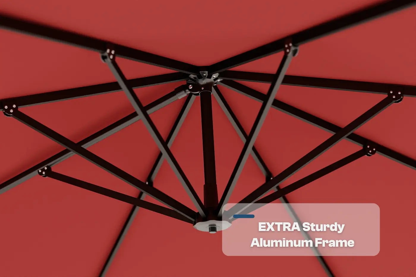 Close-up of an umbrella with a black metal frame against a red background, labeled 'Extra Sturdy Aluminum Frame'.