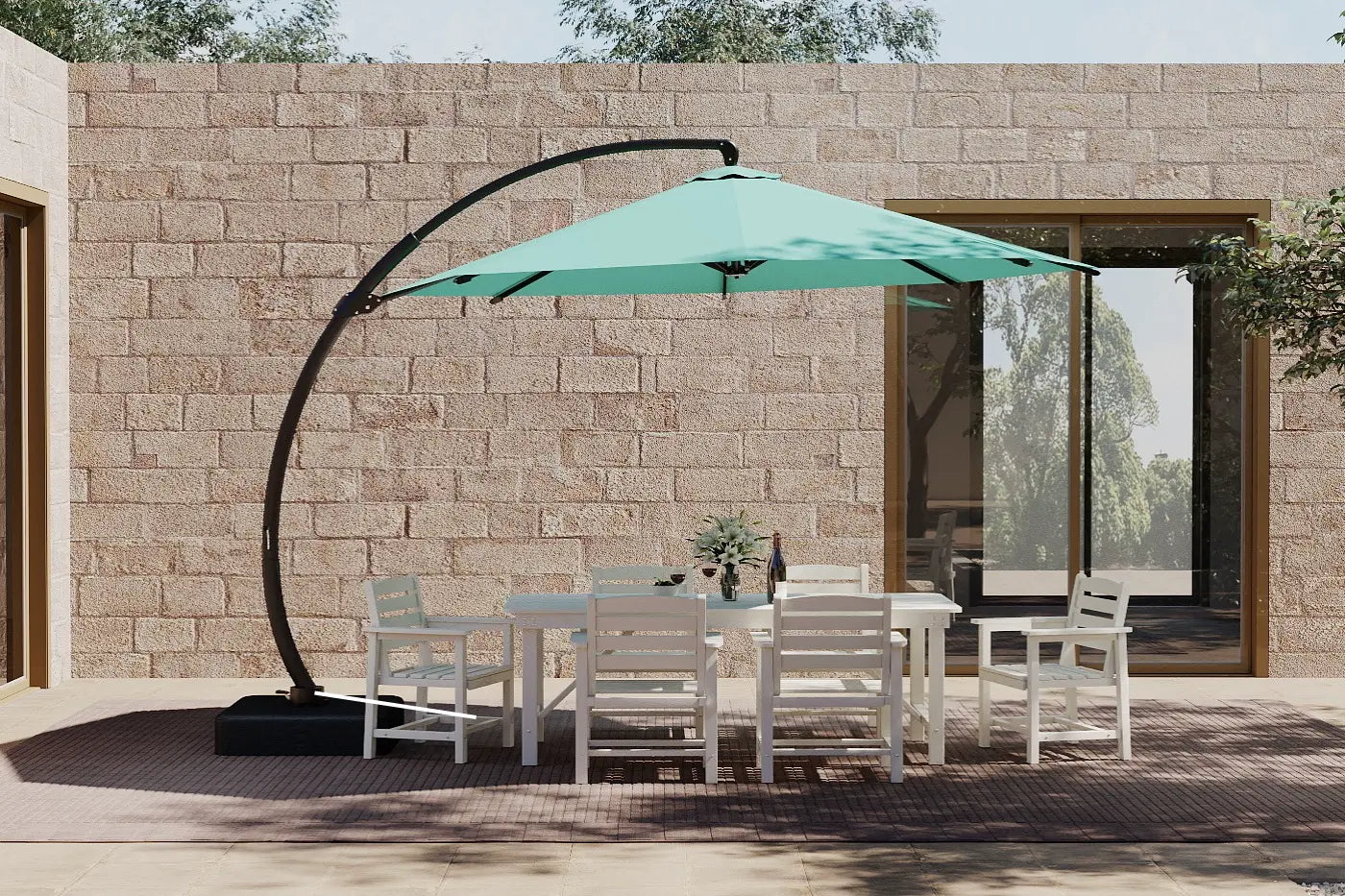 Outdoor patio set with a large green umbrella against a stone wall.
