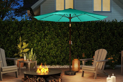 Outdoor patio scene with a teal umbrella, chairs, fire pit, and candles.