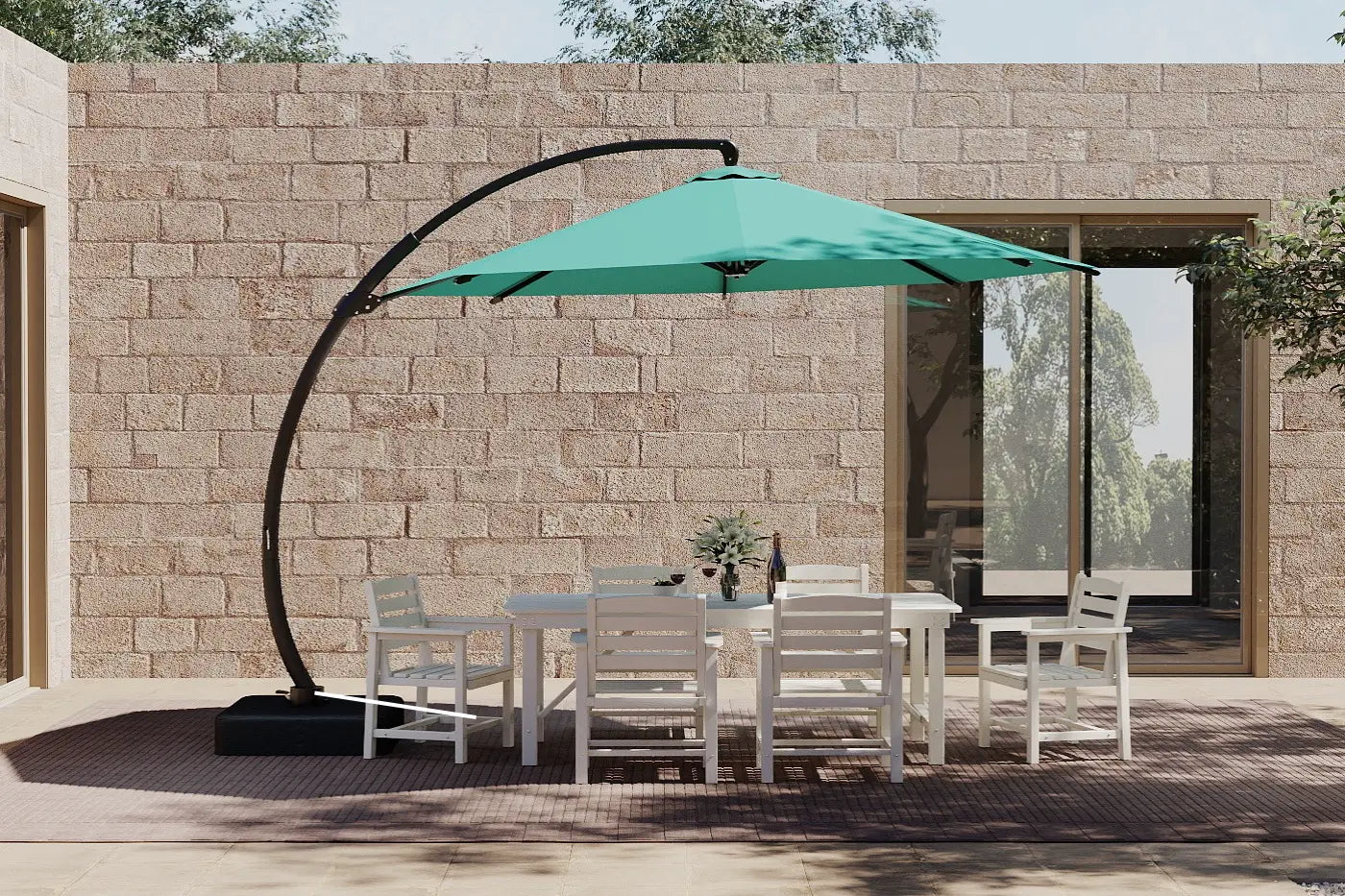 Outdoor patio set with a large green umbrella against a stone wall.