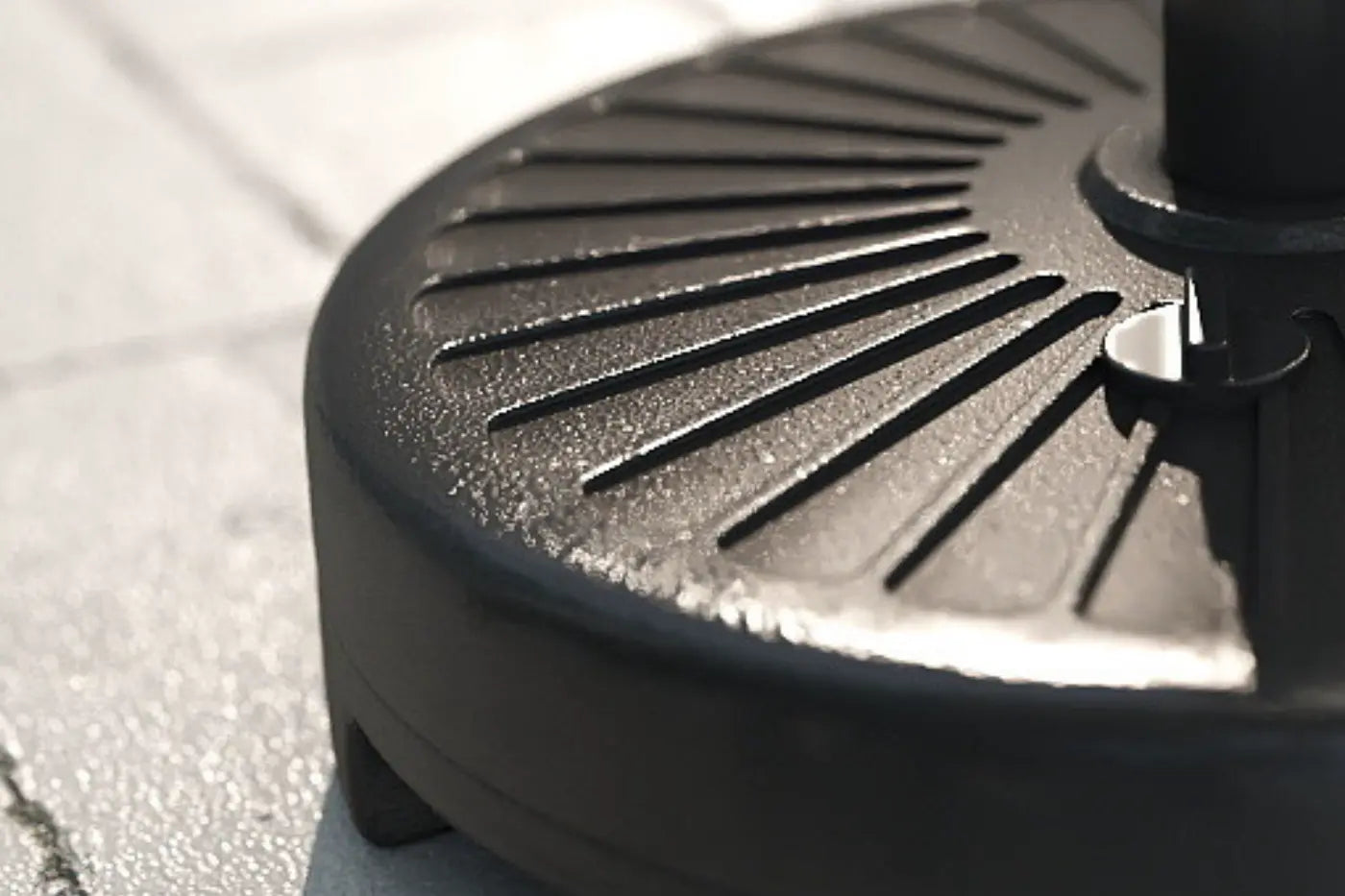 Close-up of a black grill pan on a paved surface