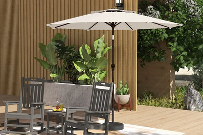 Patio set with chairs, table, and umbrella on a wooden deck with plants in the background.