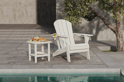 White Adirondack chair and side table by a poolside with a tree in the background.