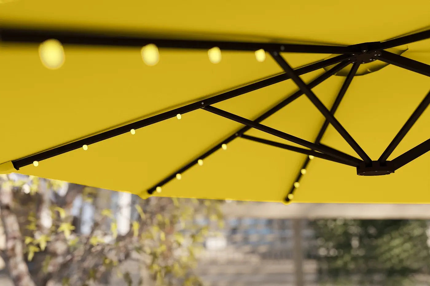 Close-up of a yellow umbrella with black support structure, blurred background