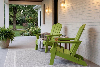 Two green Adirondack chairs on a porch with a white brick wall and outdoor setting.