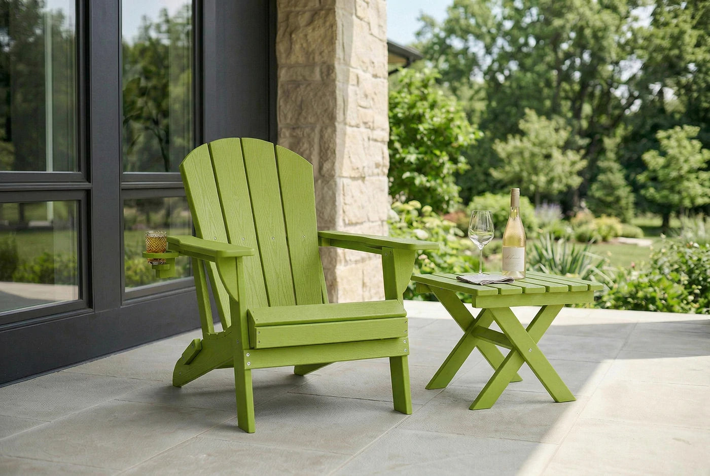 Green Adirondack chair and table on a patio with a view of trees and a building.