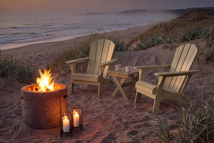 Two HDPE Adirondack chairs around a fire pit on a sandy beach at dusk.
