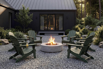 Outdoor setting with green Adirondack chairs around a fire pit in front of a dark-colored building.