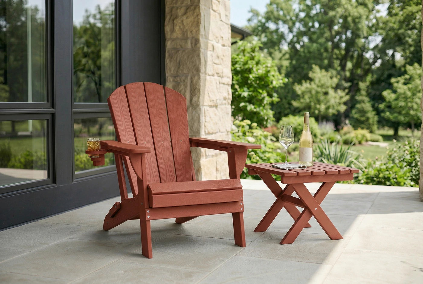 Red Adirondack chair and small table on a patio with a garden view.
