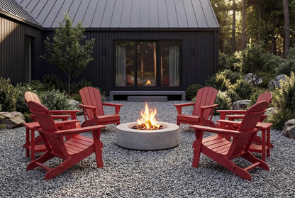 Red Adirondack chairs around a fire pit in front of a dark-colored building with large windows.