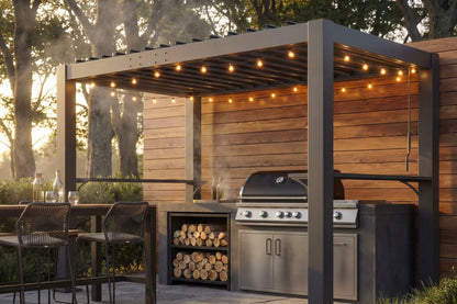 Outdoor kitchen with grill, cabinets, and chairs under a louvered pergola with string lights.