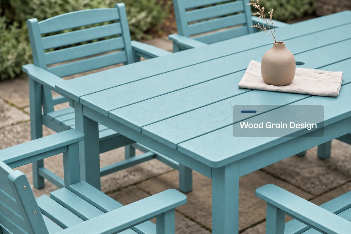 An Aruba blue outdoor dining set featuring a slatted rectangular table and matching armchairs on a stone patio, with a small beige vase on the table. A text overlay reads 'Wood Grain Design'.