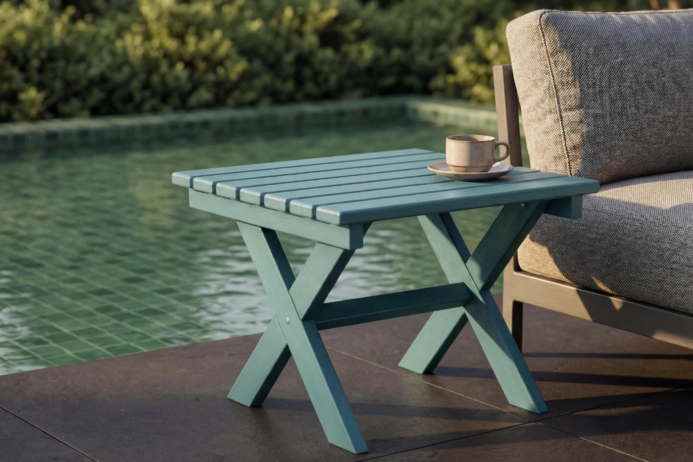 folding table with a cup and saucer on a patio by a pool