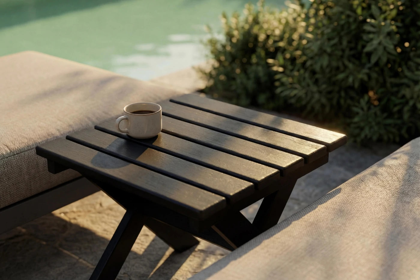 Wooden table with a cup on it by a poolside