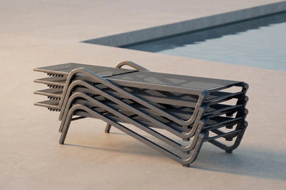 Stack of modern lounge chairs by a poolside