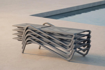 Stack of modern lounge chairs by a pool