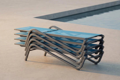 Stack of blue lounge chairs with metal frames near a pool
