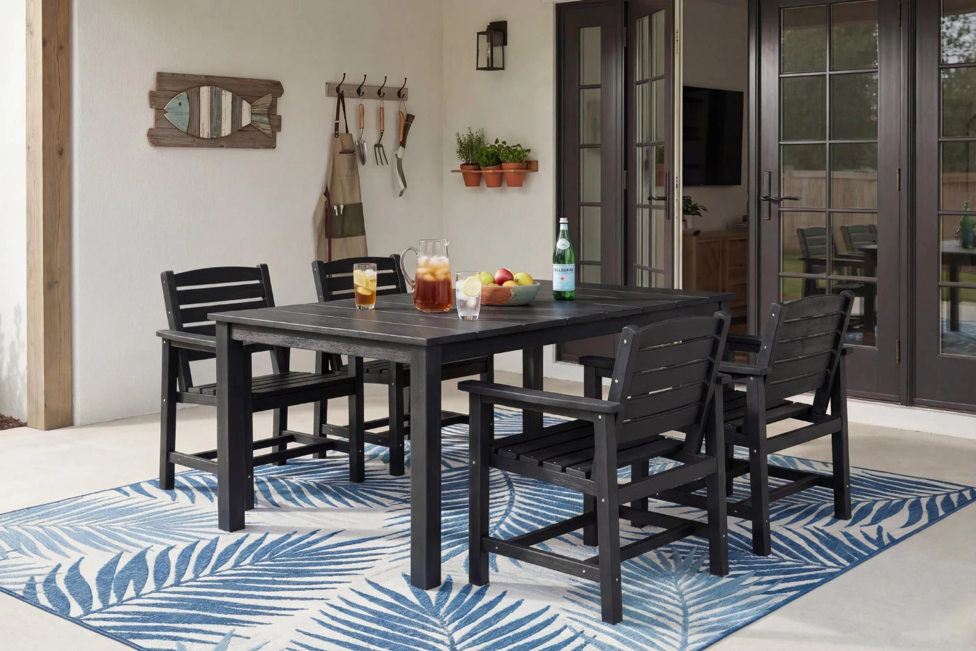 Outdoor dining set with table and chairs on a blue and white patterned rug.