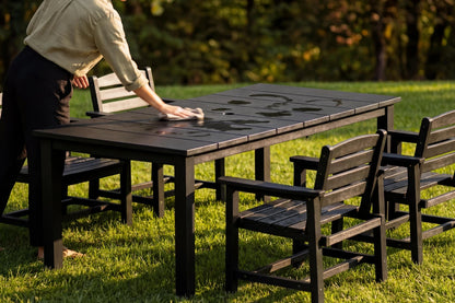 Person playing a board game on an outdoor table with chairs in a park setting
