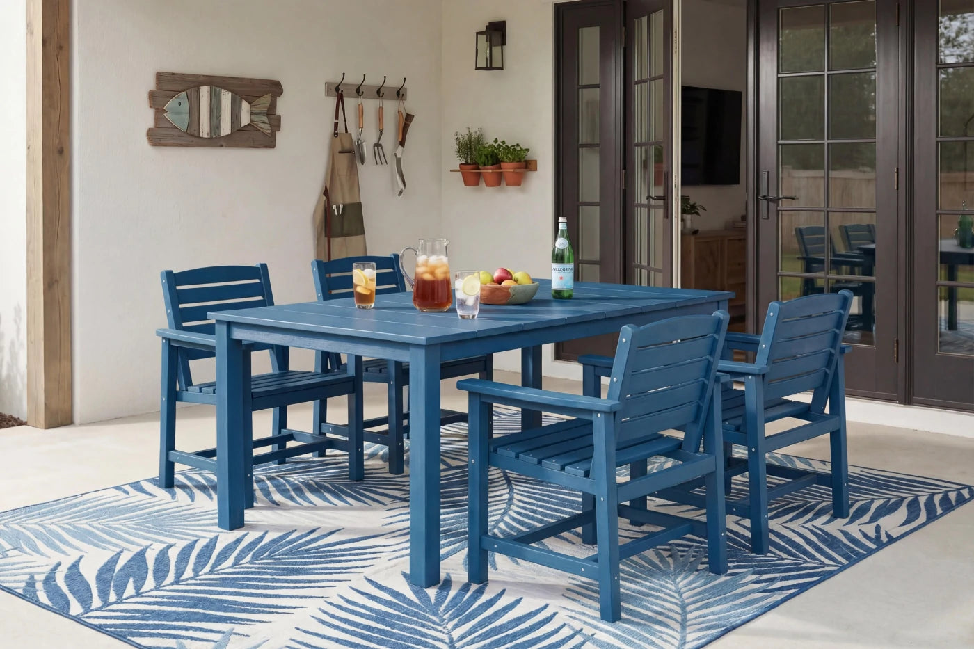 Blue outdoor dining set with table and chairs on a patterned rug.