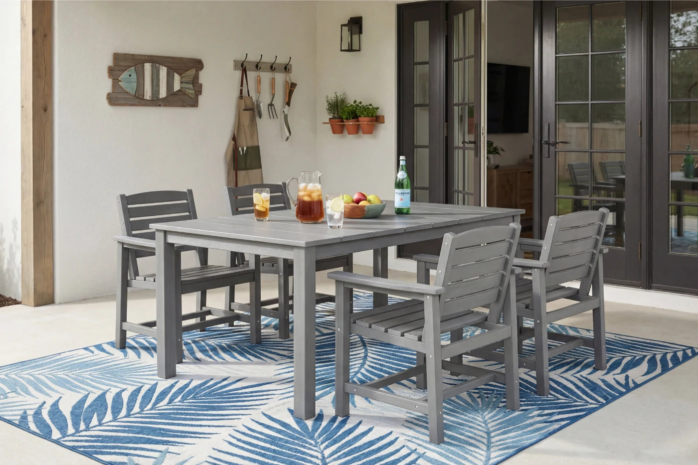 Outdoor patio set with table and chairs on a blue and white patterned rug.