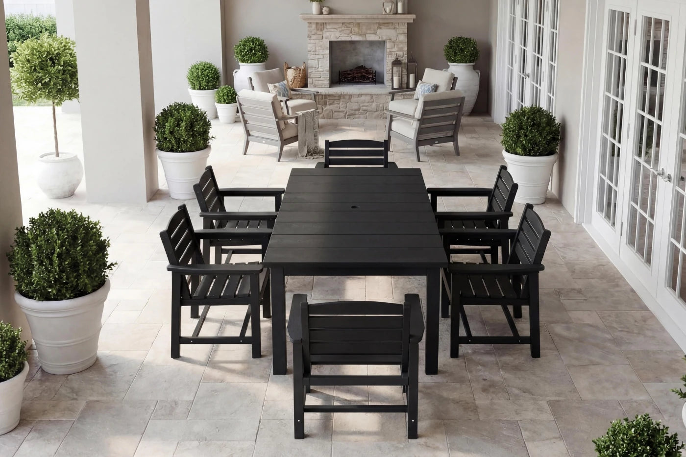 Outdoor patio set with black table and chairs on a stone patio.