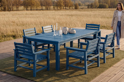 Blue outdoor dining set with chairs on a wooden deck overlooking a field.