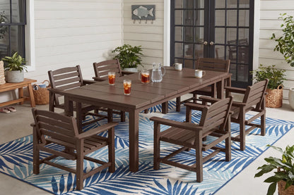 Outdoor dining set with a table and chairs on a patio with a blue and white patterned rug.