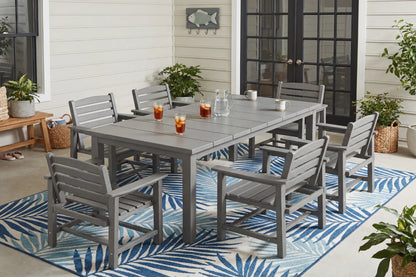 Outdoor patio set with gray table and chairs on a blue and white patterned rug.