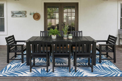 Outdoor dining set with black table and chairs on a blue and white patterned rug.