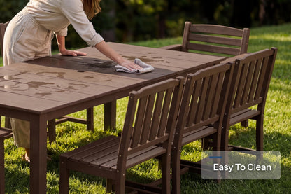 Person cleaning an outdoor table with chairs on a grassy area, emphasizing ease of cleaning.