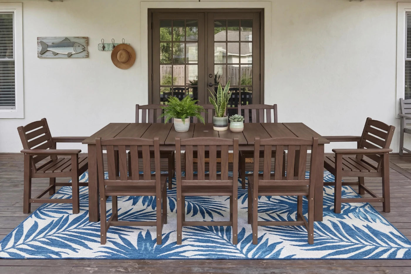HDPE  outdoor dining set with chairs and table on a deck with a blue and white patterned rug.