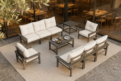 Outdoor patio furniture set with cushions on a stone patio.