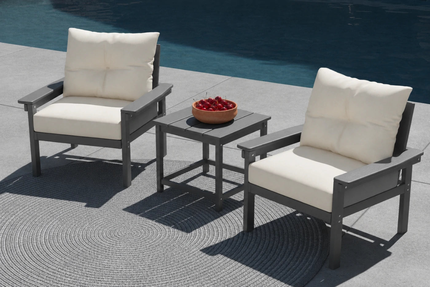 Outdoor patio set with two chairs and a table by a pool