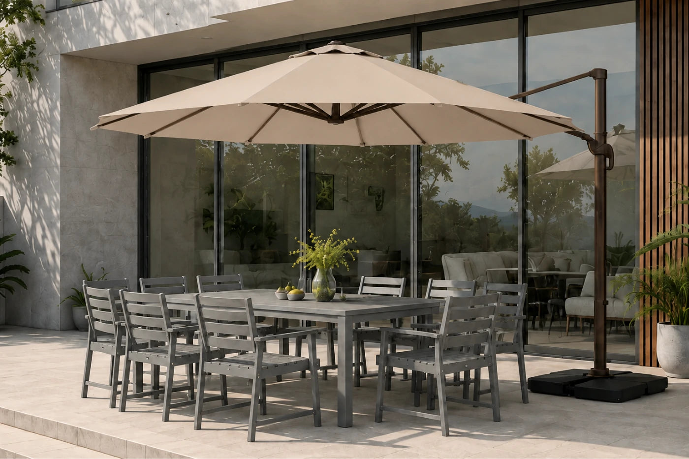 Outdoor patio dining set with a rectangular gray table, eight matching gray chairs, a large beige patio umbrella with a dark metal cantilever pole, and a modern glass-walled building in the background.
