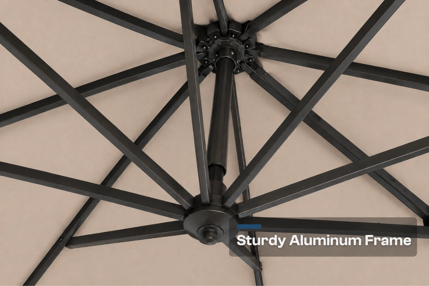 Close-up underside view of a patio umbrella showing a dark aluminum frame structure against a beige canopy background, with the text 'Sturdy Aluminum Frame' in the lower right corner.