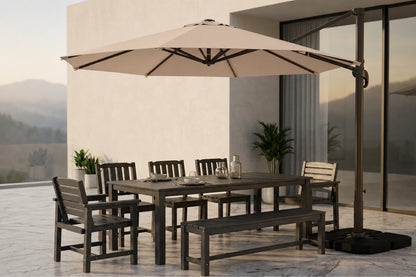 Outdoor patio dining set with a rectangular table, matching chairs and bench, and a large beige cantilever umbrella on a tiled terrace beside a modern building.