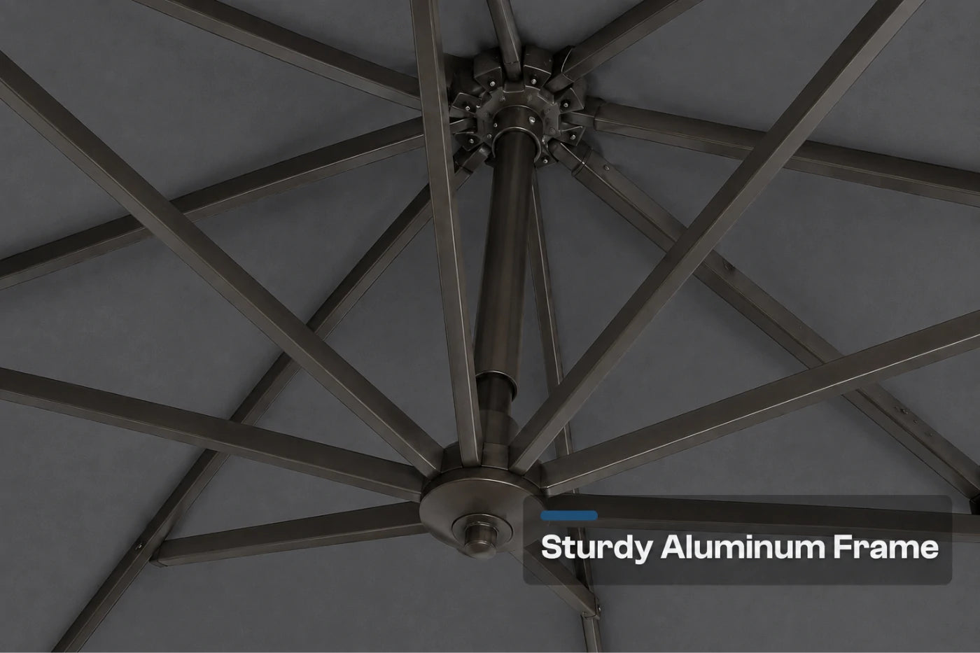 Close-up of an aluminum patio umbrella frame with radiating metal ribs and a central pole, shown against a dark gray canopy background with the text 'Sturdy Aluminum Frame' in the lower right.