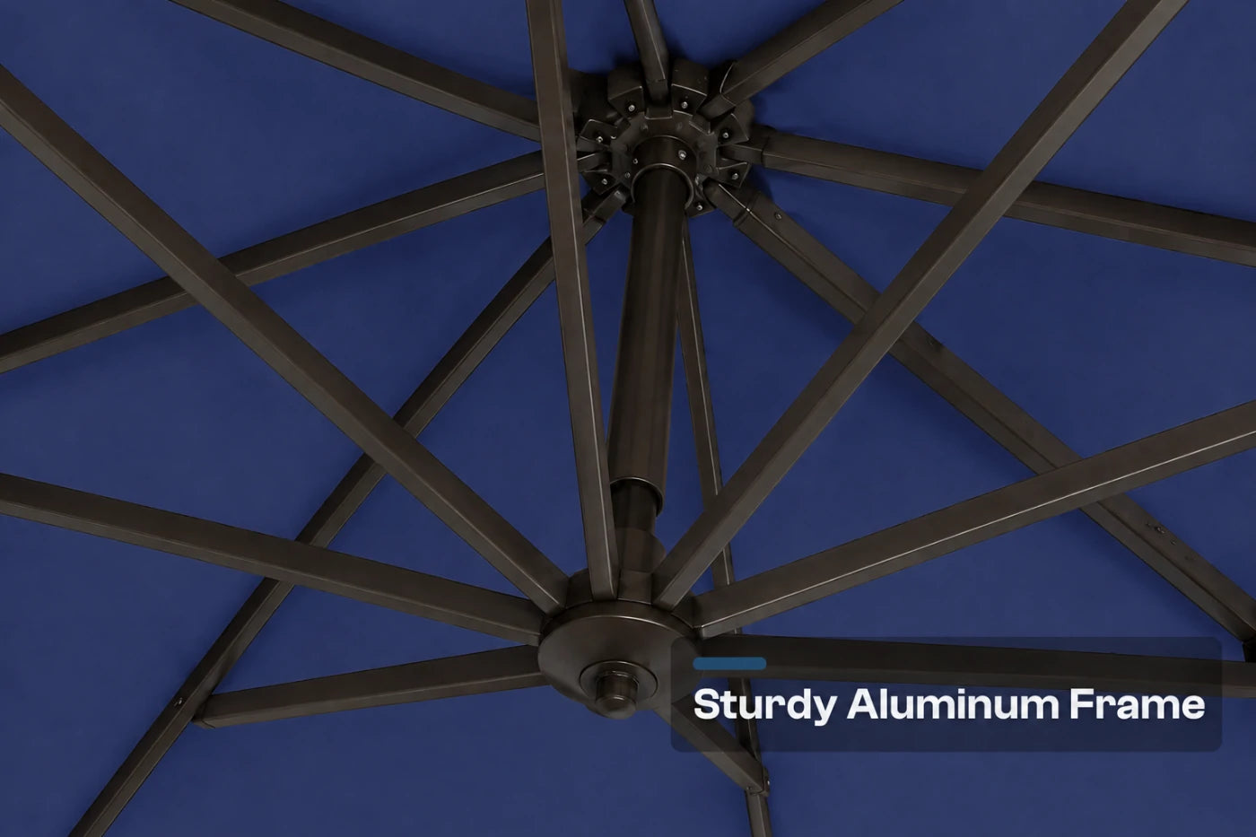 Close-up underside view of a patio umbrella showing a dark aluminum frame structure against a navy blue canopy background, with the text 'Sturdy Aluminum Frame' in the lower right corner.