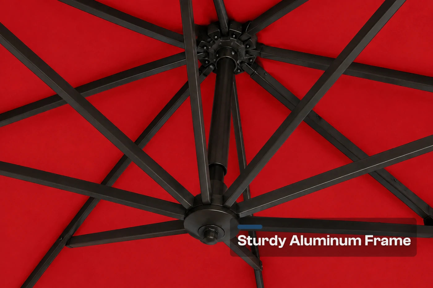 Close-up of the underside of a red patio umbrella showing the black aluminum frame ribs and central hub, with a text overlay reading 'Sturdy Aluminum Frame'.