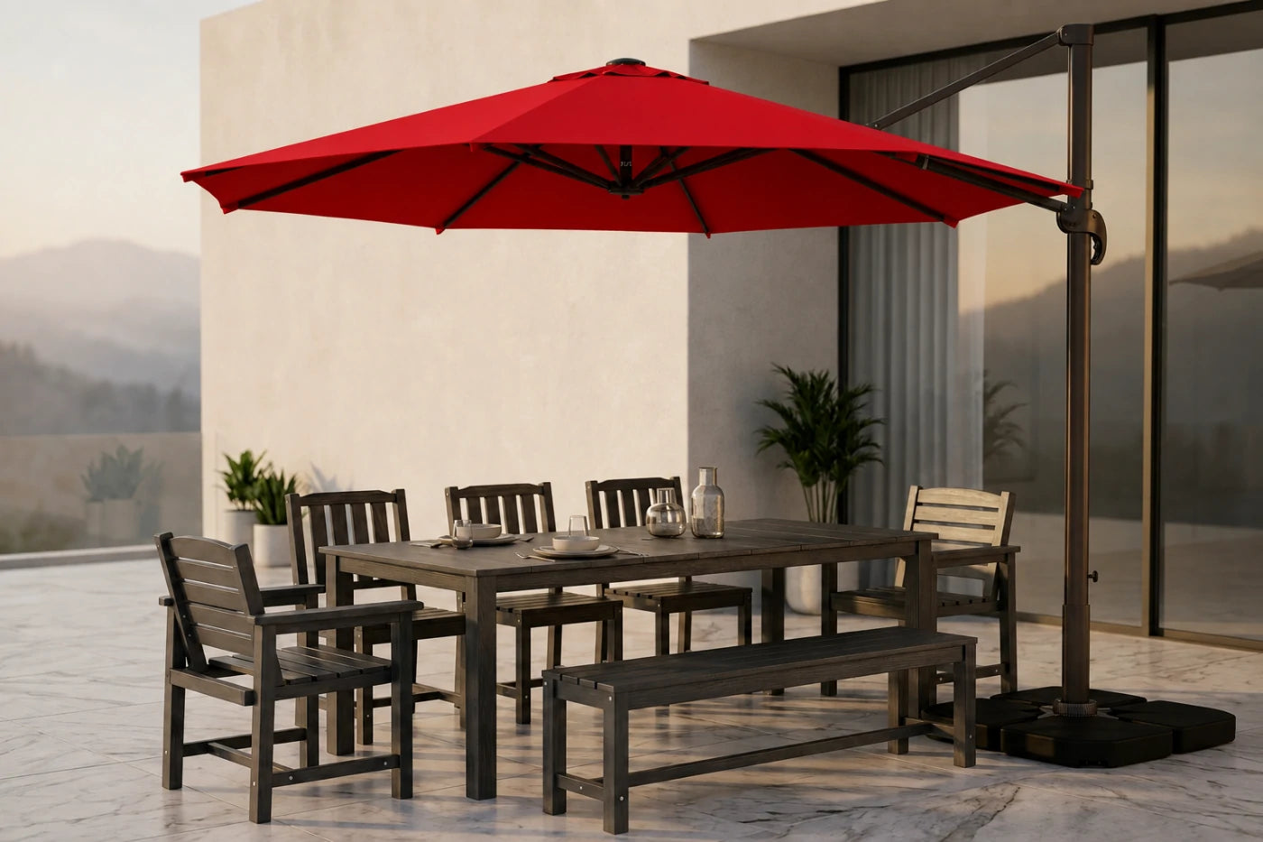 A large red cantilever patio umbrella with a dark metal frame and base, shading a rectangular dining table, four chairs, and a bench on a modern outdoor patio.
