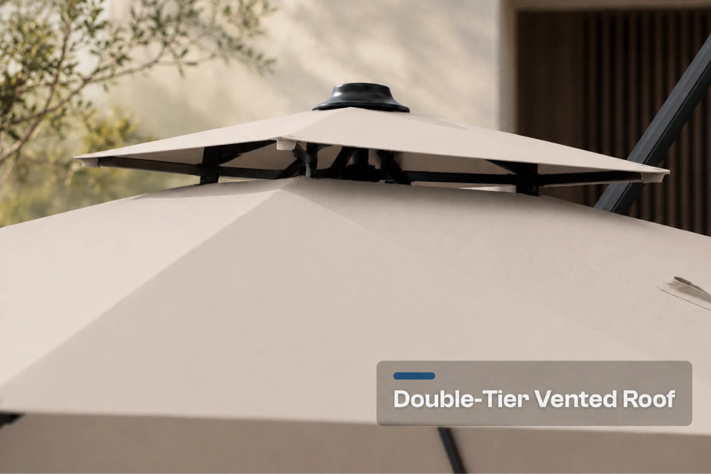Close-up of a patio umbrella showing a double-tier vented roof design, with a beige canopy and a text overlay that reads 'Double-Tier Vented Roof'.